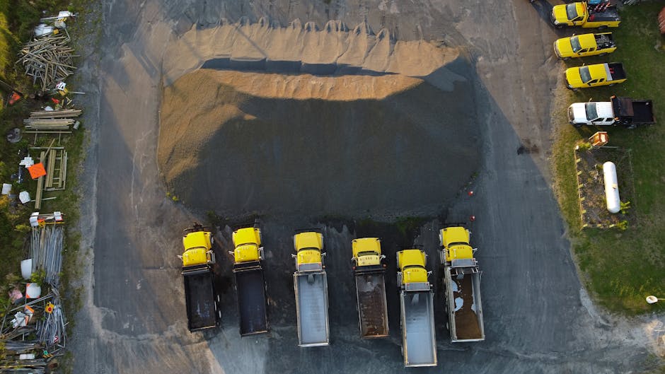 Inżynier w kasku dokonujący wizualnej oceny jakości kruszywa na placu budowy